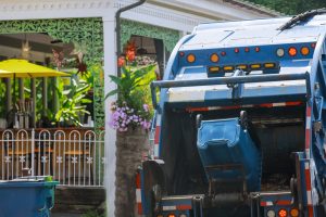 Garbage truck outside residential home representing common signs of mold growth and moisture issues in buildings
