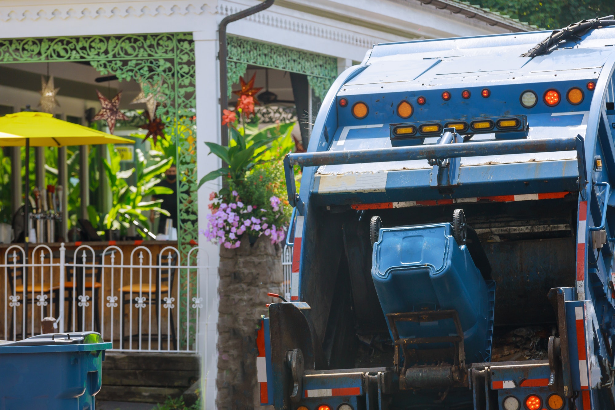 Garbage truck outside residential home representing common signs of mold growth and moisture issues in buildings